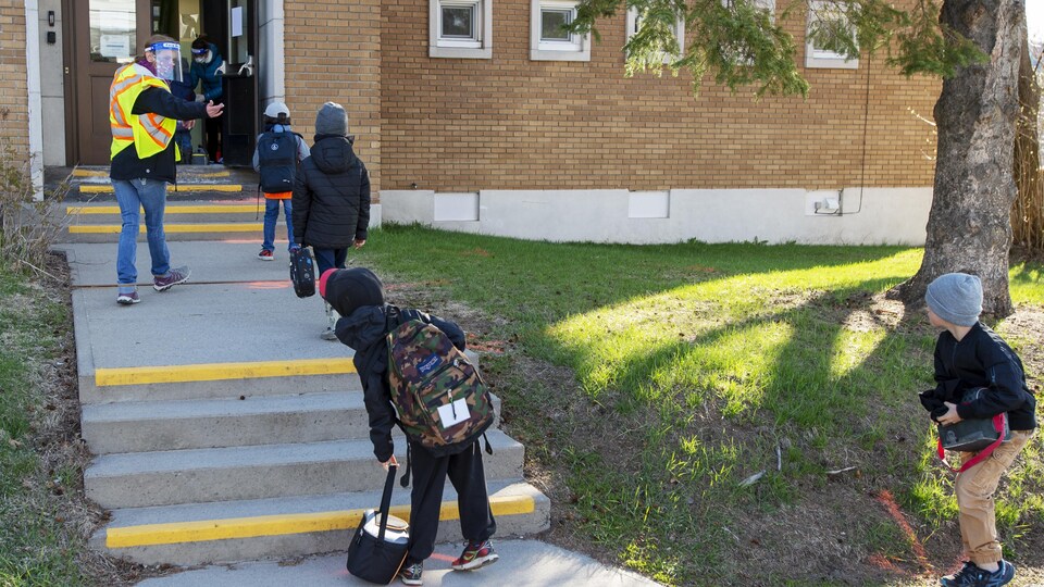 Des élèves qui entrent dans une école.