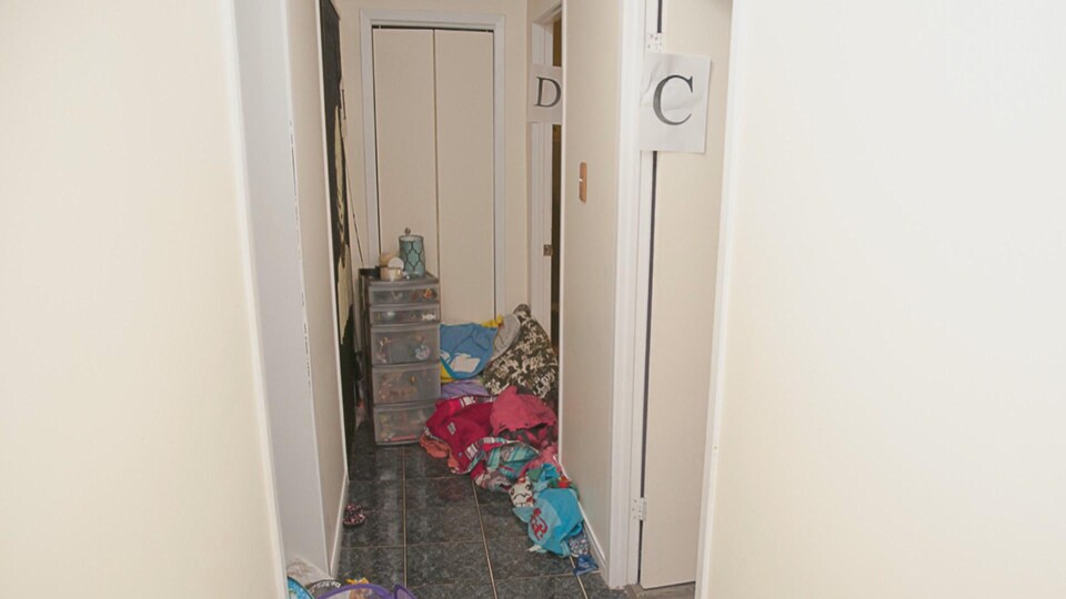 Un corridor avec des objets par terre et un classeur au fond.