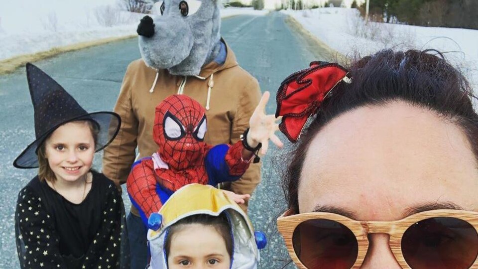 Guillaume porte une tête de mascotte de loup, une de ses filles porte un costume de Spiderman, une autre est déguisée en sorcière et la plus petite, en extraterrestre.