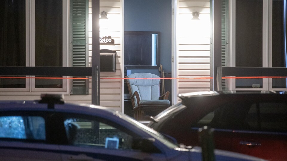 Des voitures de police devant une maison, la nuit