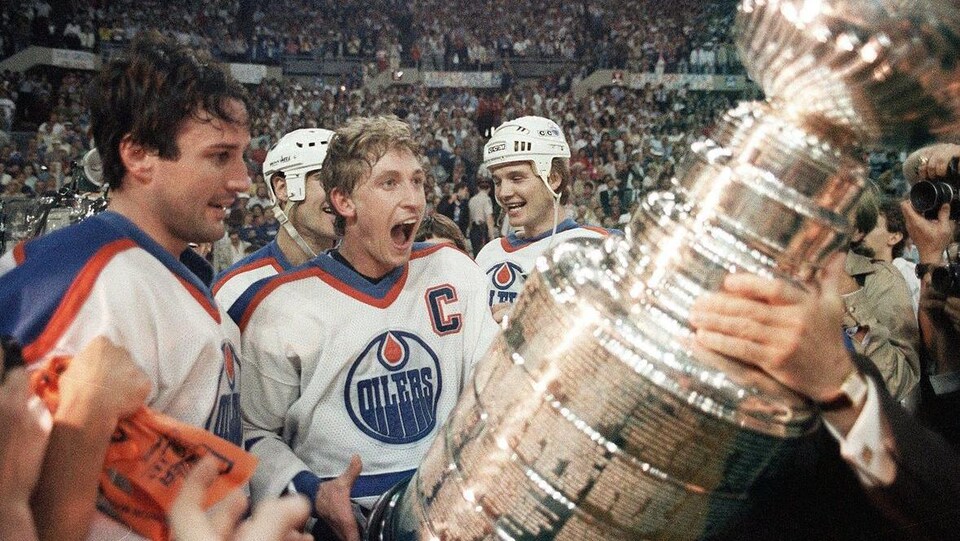 Wayne Gretzky se voit confier la Coupe Stanley après la victoire de son équipe en finale, en 1985.