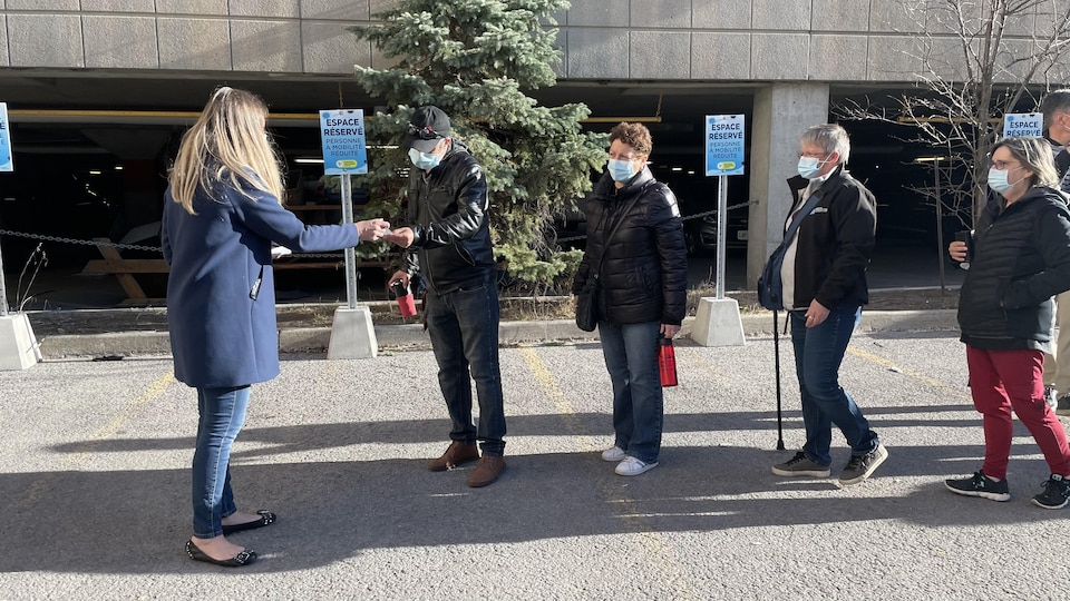 Une femme remet un morceau de papier à un résident en tête de file.