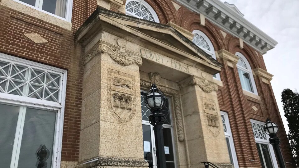 Un bâtiment en briques rouges et en pierre sur lequel il est inscrit « Court House ».