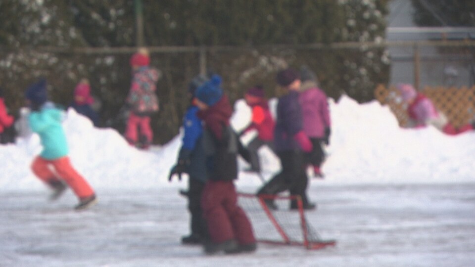 Cour d'école en hiver avec des enfants qui jouent.