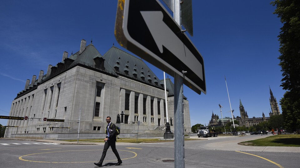Un homme masqué passe devant la Cour suprême du Canada à Ottawa.
