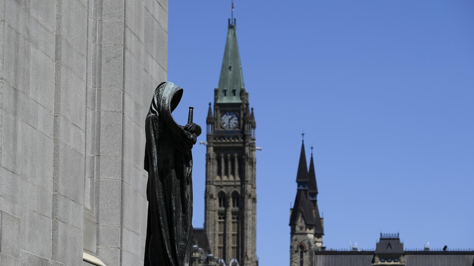 La sculpture de la justice se profile devant la tour de la Paix.