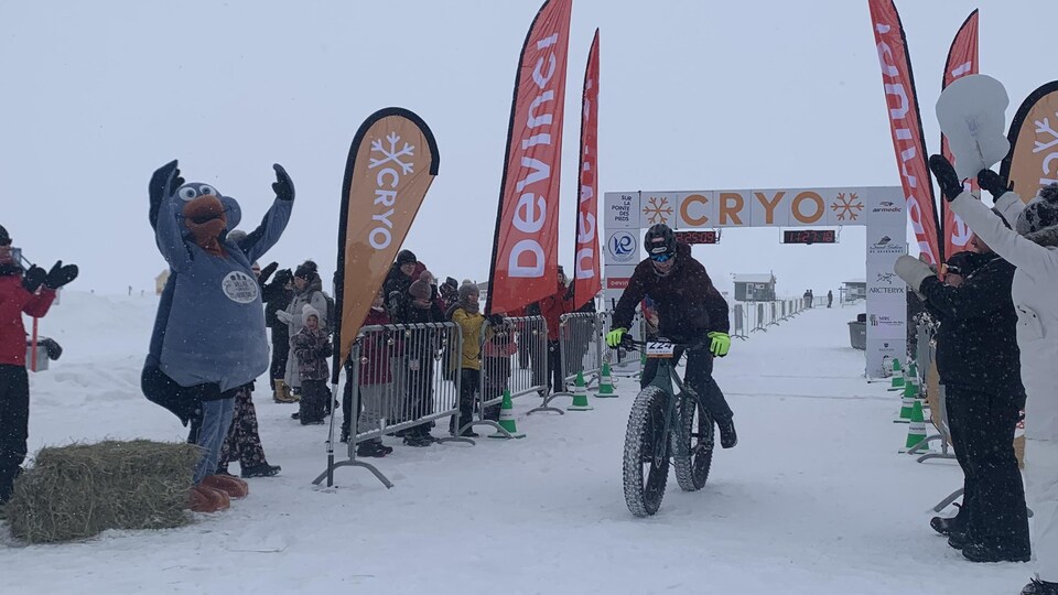 Un cycliste franchit la ligne d'arrivée.