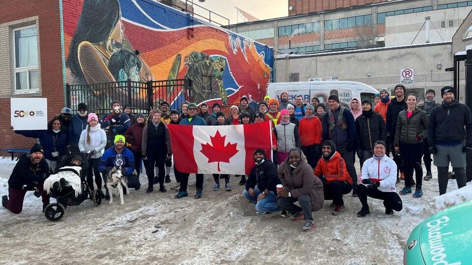Un groupe de personnes avec un drapeau du Canada à l'avant-plan.