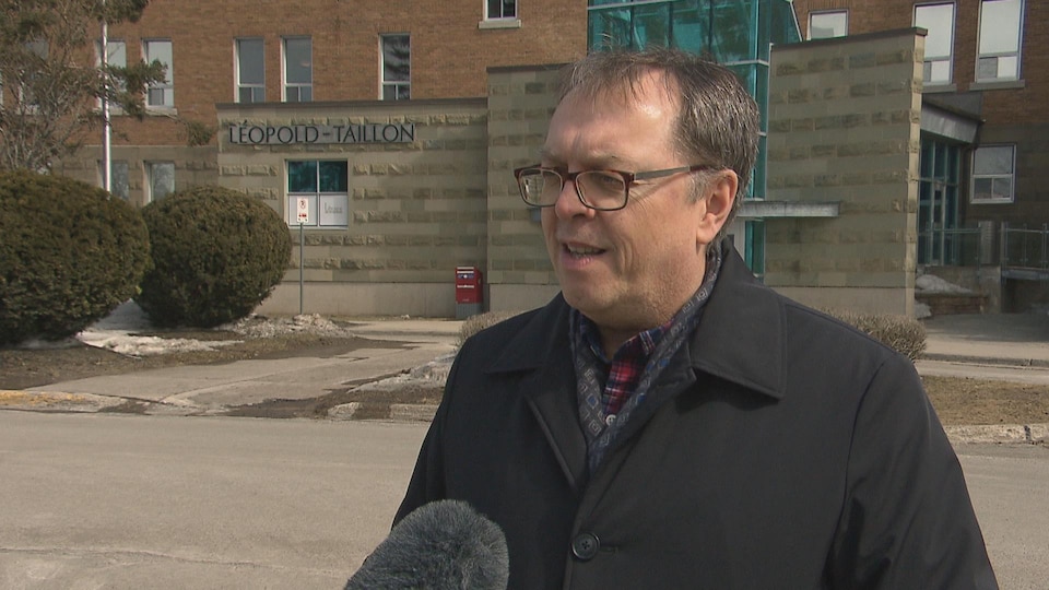 Jacques-Paul Couturier en entrevue devant un édifice du campus de Moncton.