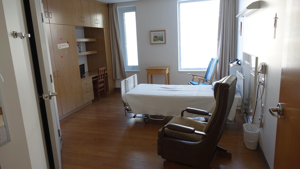 Un fauteuil avec un lit d'hôpital dans une chambre
