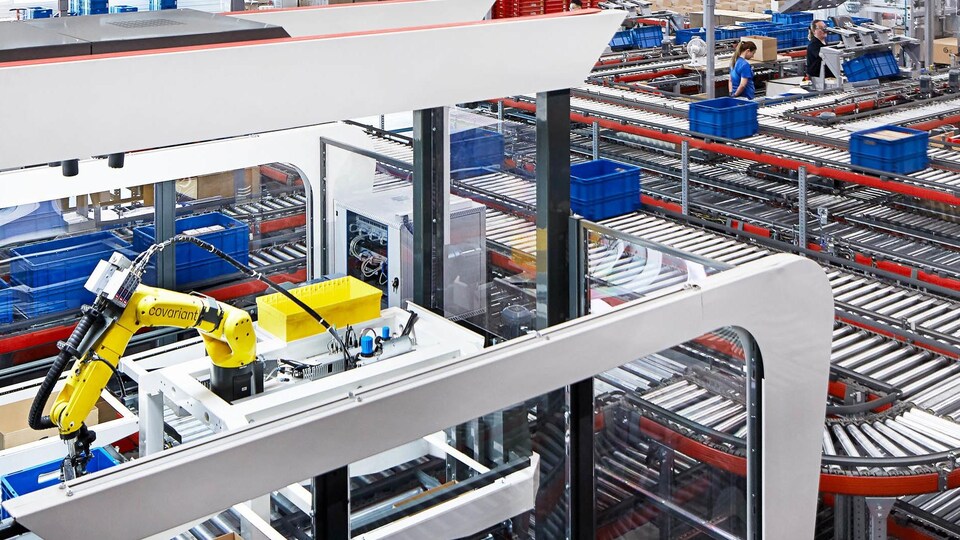 Un bras robotique dans une marée de convoyeurs.