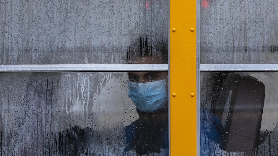 Un élève masqué dans un autobus.