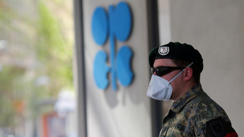 Un soldat autrichien se tient à côté du logo de l'Organisation des pays exportateurs de pétrole (OPEP) devant le siège de l’organisation à Vienne.