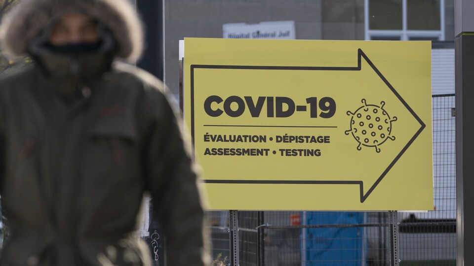 Un panneau indiquant la direction à suivre pour accéder à une clinique de dépistage.