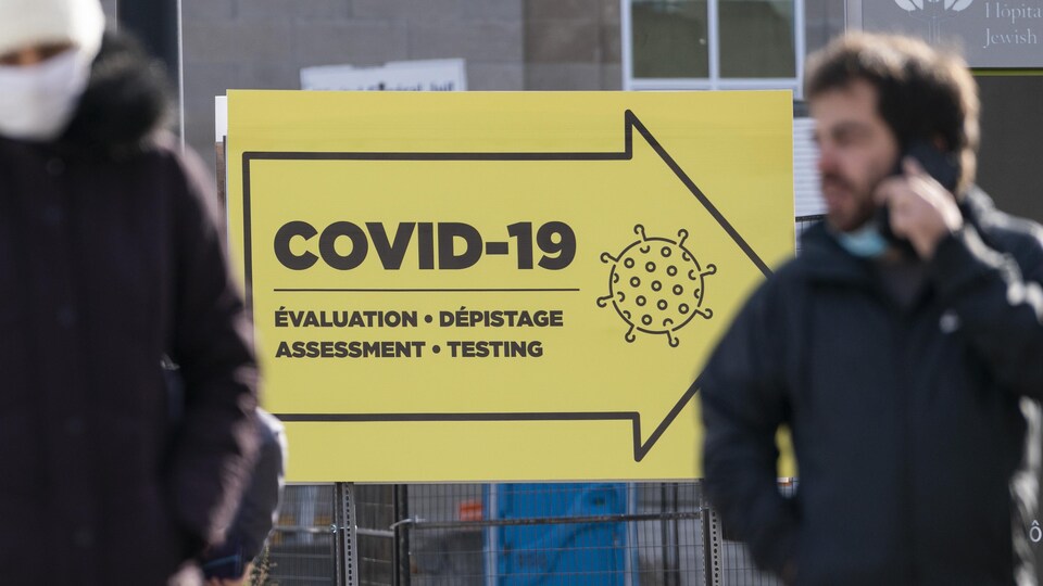 Un panneau indique la direction à prendre pour accéder à une clinique de dépistage.