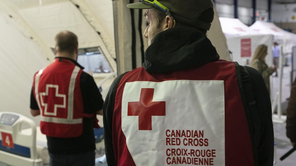 Un employé portant un dossard avec le sigle de la Croix-Rouge.