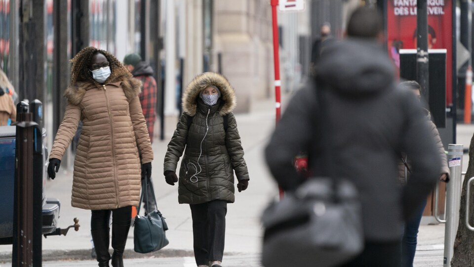 Des gens marchent sur un trottoir de la ville.