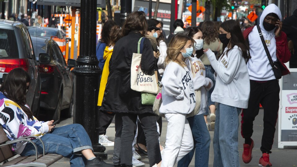 Une foule de gens se trouve sur un trottoir de la métropole.