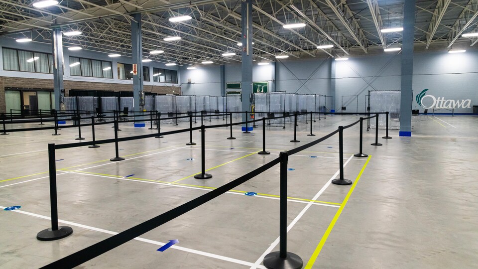Des rubans pour organiser les files d'attente dans une salle vide.
