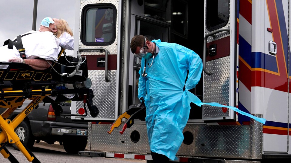 Des ambulanciers américains s’apprêtent à transporter un patient potentiellement atteint de la COVID-19.