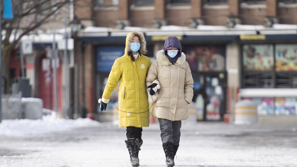 Deux femmes marchent dans la rue.