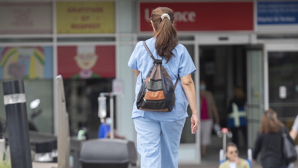 Une infirmière marche à l'extérieur d'un hôpital à Montréal.