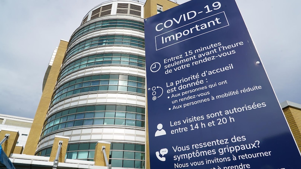 Une affiche à l'entrée de l'hôpital indique les règles de temps de visites et les consignes pour les rendez-vous médicaux.