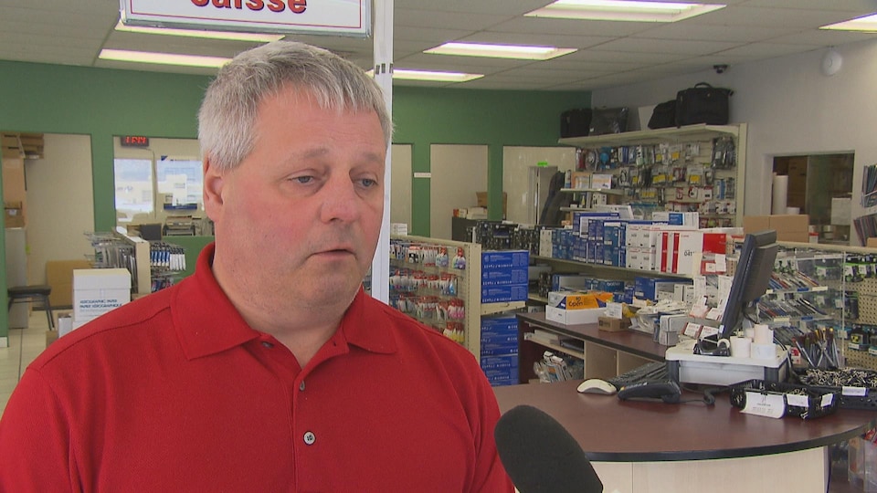 Un homme interviewé dans un magasin d'informatique.