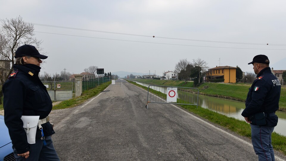 Des policiers italiens contrôlent l'entrée du village de Vo'Euganeo en raison de l'éclosion de la COVID-19, près de Venise, en Italie.