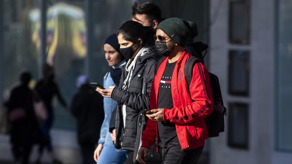 De jeunes adultes marchent dans une rue de Vancouver.