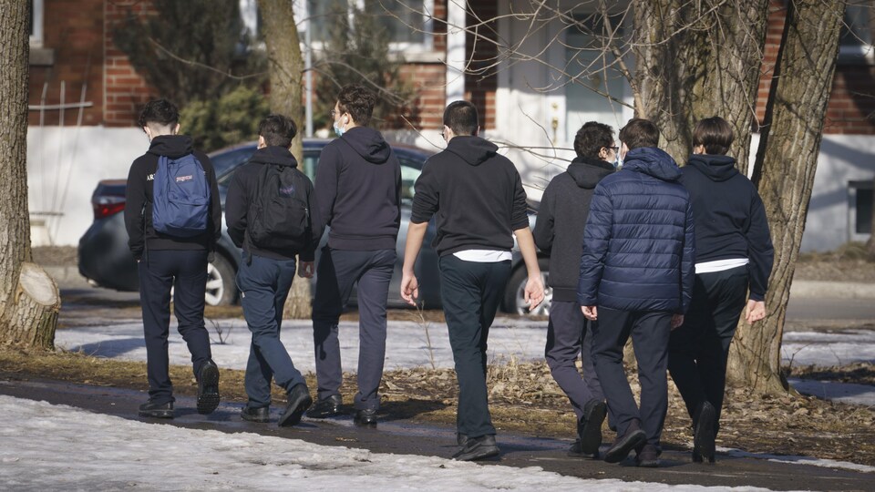 Des jeunes marchent à Montréal. Certains portent des masques.