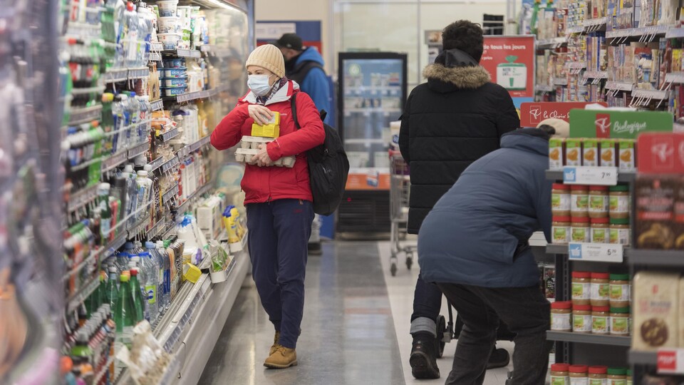 Des gens font leurs achats dans une épicerie.