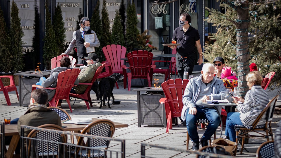 Des gens prennent un verre sur une terrasse extérieure du centre-ville d'Ottawa.