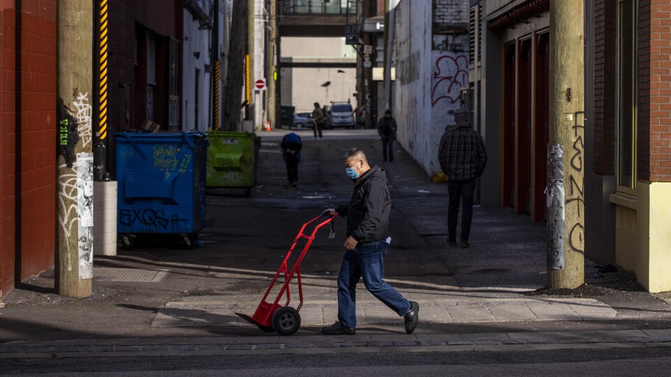 Un homme marche dans une rue de Vancouver.
