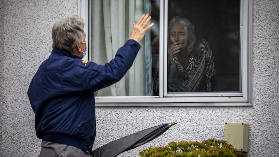 John Wilvers rend visite à sa mère Elizabeth Jeppesen, 94 ans, qui a été testée positive à la COVID-19 à sa résidence Tabor Home à Abbotsford, en Colombie-Britannique, le mercredi 18 novembre 2020. 