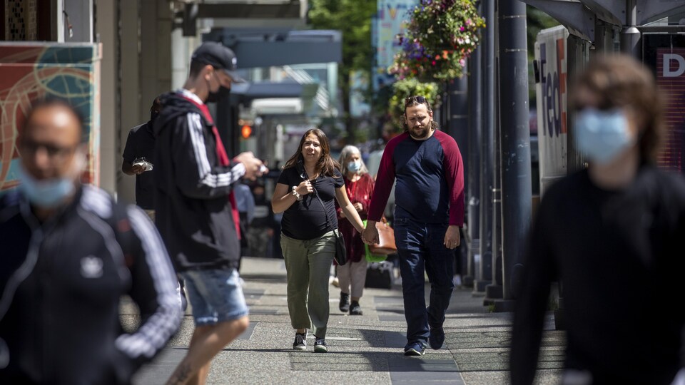 Des gens dans la rue Granville au centre-ville de Vancouver. 