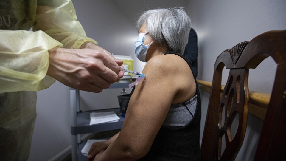 Une résidente reçoit une dose du vaccin Pfizer-BioNTech COVID-19 au foyer de soins de longue durée Caboto Terrace, à Toronto.