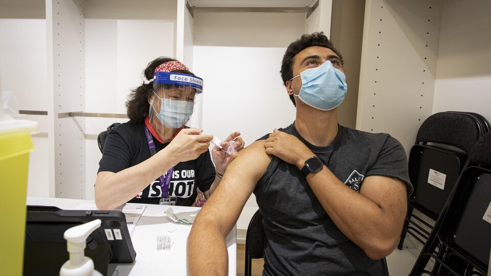 Iman Dominguz se fait injecter le vaccin dans l'épaule.