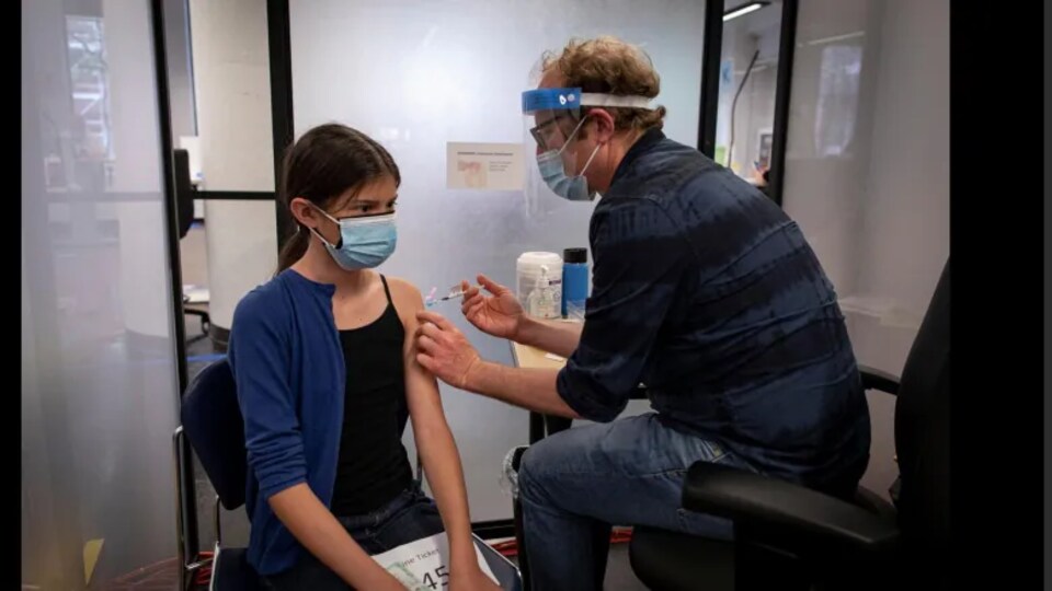 Une adolescente se fait vacciner contre la COVID-19.
