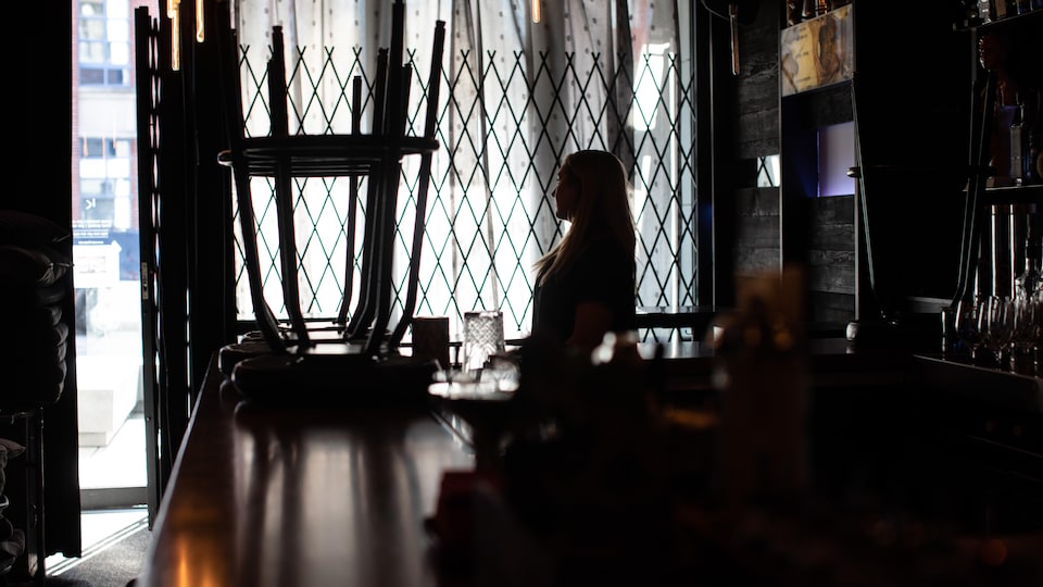 Une femme dans un bar sombre.