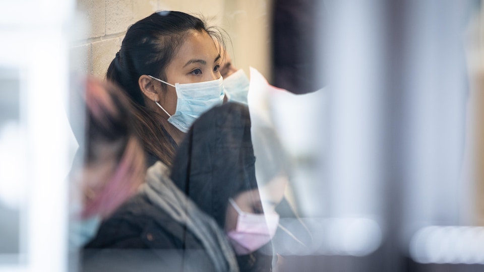 Des gens portent un masque et attendent dans une clinique de Vancouver. 