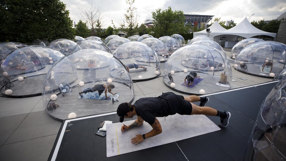 Des élèves suivent leur cours de yoga dans des bulles à Toronto pour se protéger de la COVID-19.