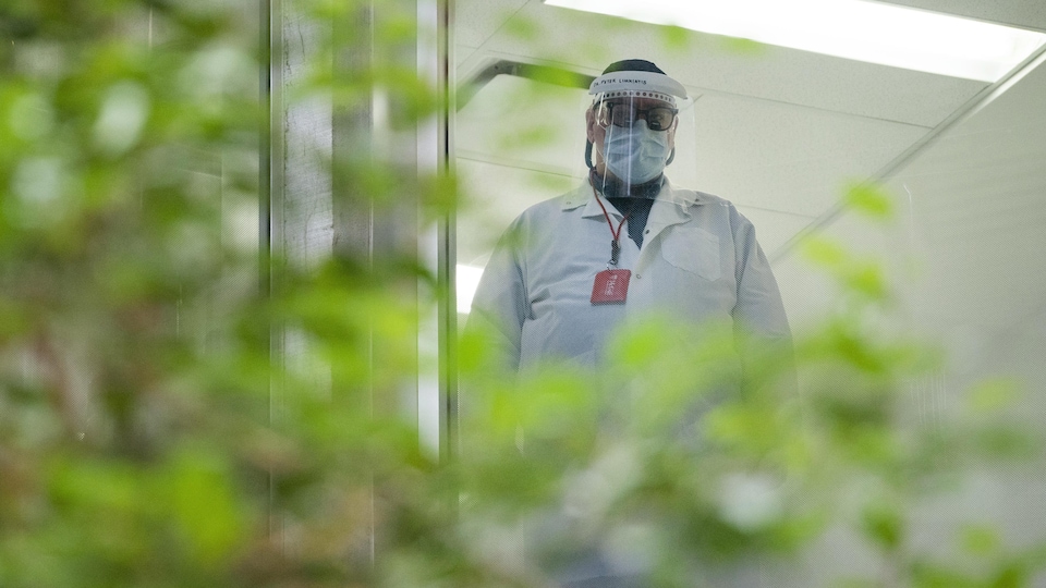 Un employé de la santé portant un masque et une visière.