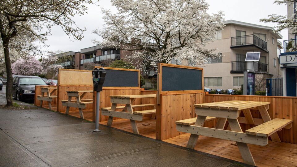 Une terrasse construite en bois sur des espaces de stationnement.