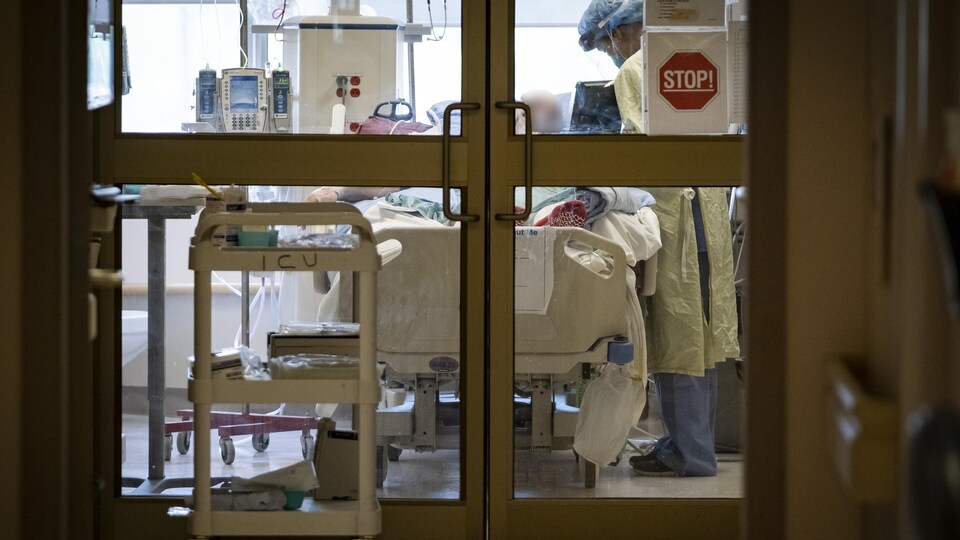 Une infirmière soigne un patient aux soins intensifs à l'Hôpital général de North York.