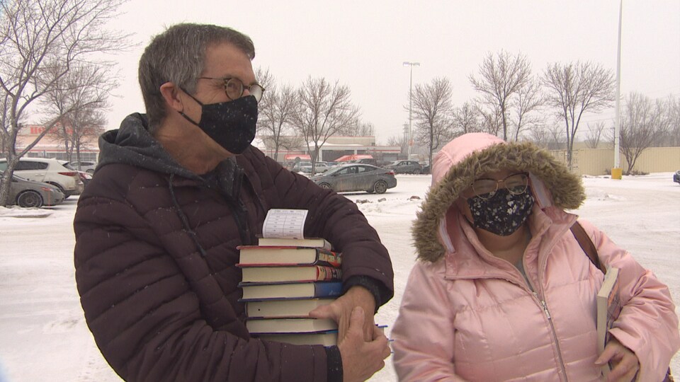 Phyllix et Tom tiennent des livres entre leurs mains.