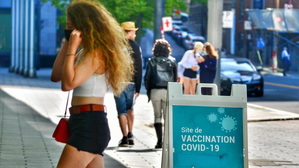 Une jeune femme entre dans un centre de vaccination contre la COVID-19 à Montréal.