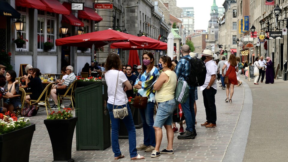 Des gens discutent dans une rue du Vieux Montréal.