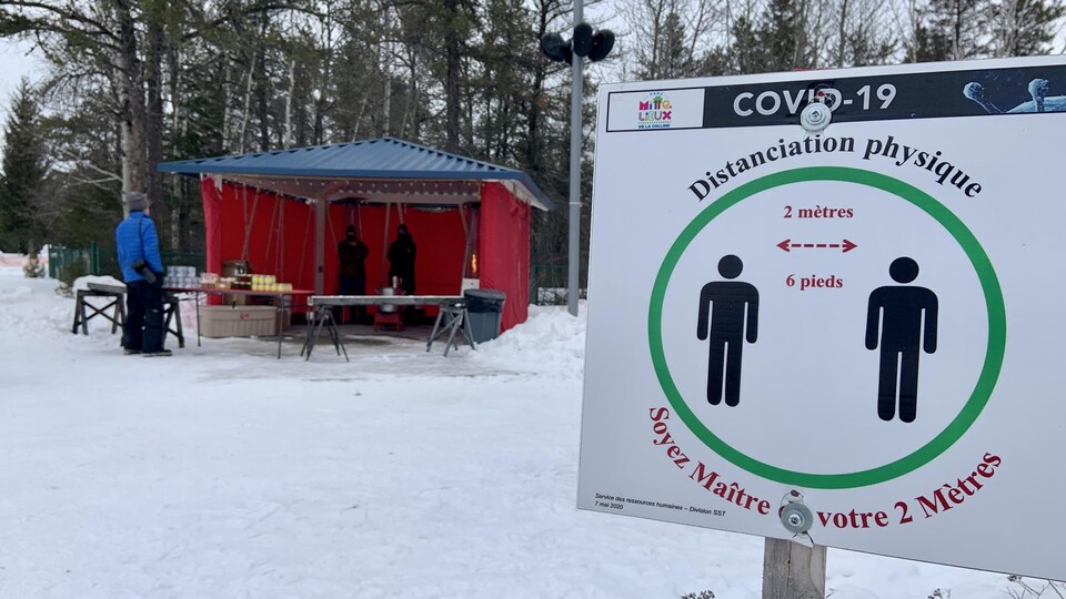 Un panneau qui demande de conserver le deux mètres.