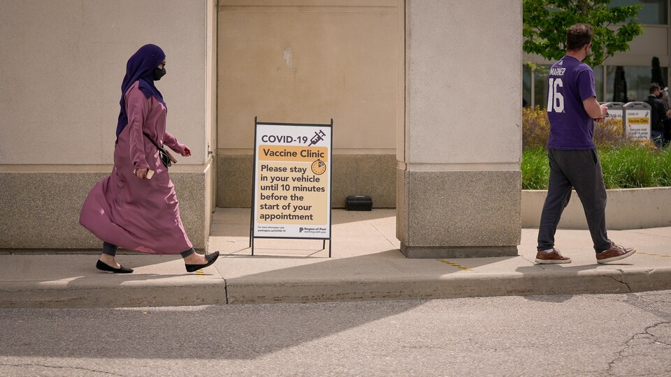 Un homme et une femme arrivent à un centre de vaccination.